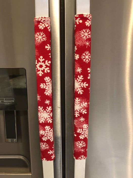 Festive winter snowflakes appliance handle covers on a kitchen refrigerator, adding holiday charm and style.