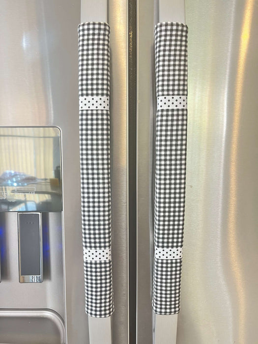 Stylish black and white buffalo plaid handle covers on refrigerator handles for decorative kitchen protection.