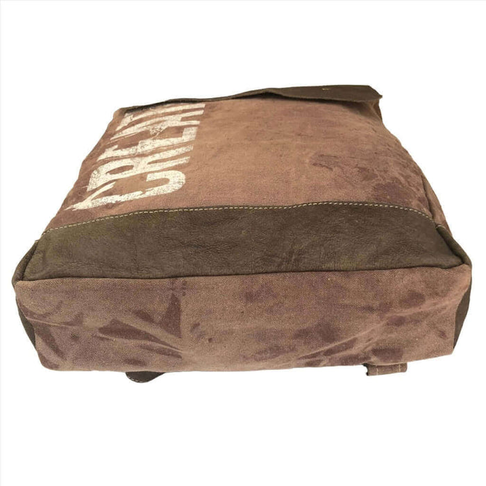 Canvas and leather backpack showing rugged design and spacious bottom view, ideal for work or outdoor activities.