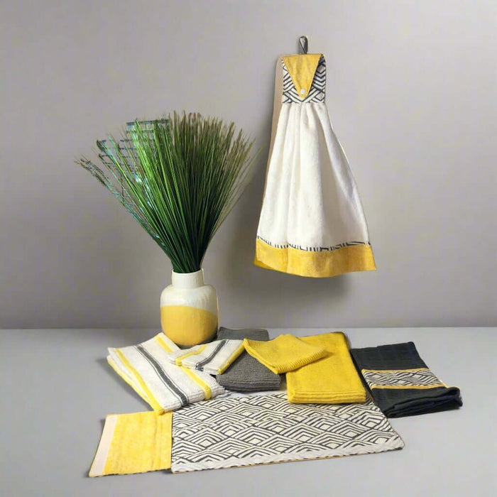 Grey yellow and white ceramic vase featuring decorative textiles and kitchen towels for modern home decor.