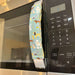 Cute puppy print appliance handle cover on a microwave, adding style and protection to kitchen handles.