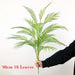Artificial Monstera plants held by a person, showcasing 18 leaves, elegantly designed for home decor.
