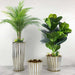 Artificial monstera plants displayed in elegant striped white and gold planters, enhancing home decor.