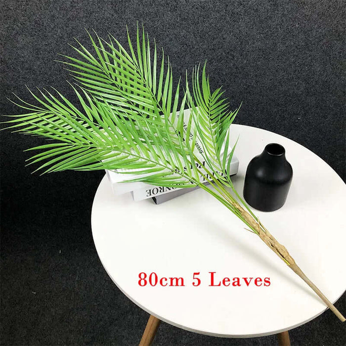 Artificial Monstera plants displayed on a table with a black vase, featuring realistic greenery and 80cm height.