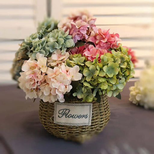 Decorative flower arrangement in a woven basket with a 'Flowers' label on a blurred background.