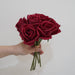 Artificial latex snow mountain rose bouquet in hand, featuring vivid red petals and realistic design.