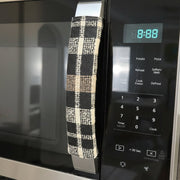 Plaid kitchen appliance handle cover wrapped around a microwave handle