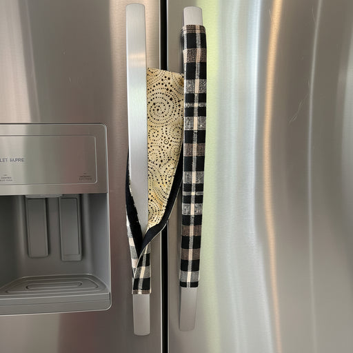 Two kitchen fridge handle covers on a stainless steel refrigerator door, showing the reverse.