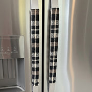 Black and cream checkered refrigerator handles on a stainless steel refrigerator.
