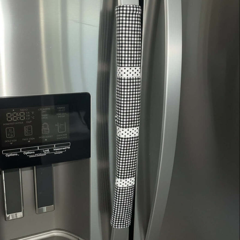 Stainless steel refrigerator with a black and white checkered handle cover.