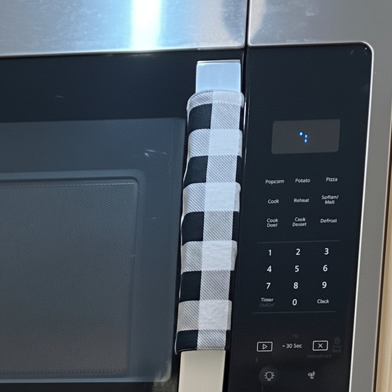 Stainless steel microwave with a black and white checkered handle cover on the handle