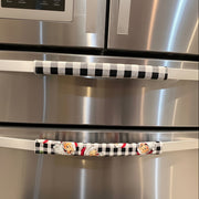 Stainless steel refrigerator with black-and-white checkered and Santa face character door handles.