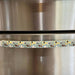 Cute puppy print appliance handle cover on a stainless steel refrigerator, adding style and protection.