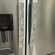 Decorative floral handle covers on a refrigerator door.