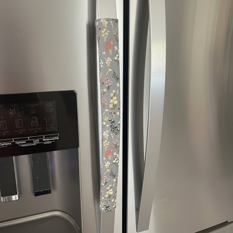 Stainless steel refrigerator with floral patterned handle cover.
