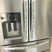 Stainless steel refrigerator with floral patterned handle covers