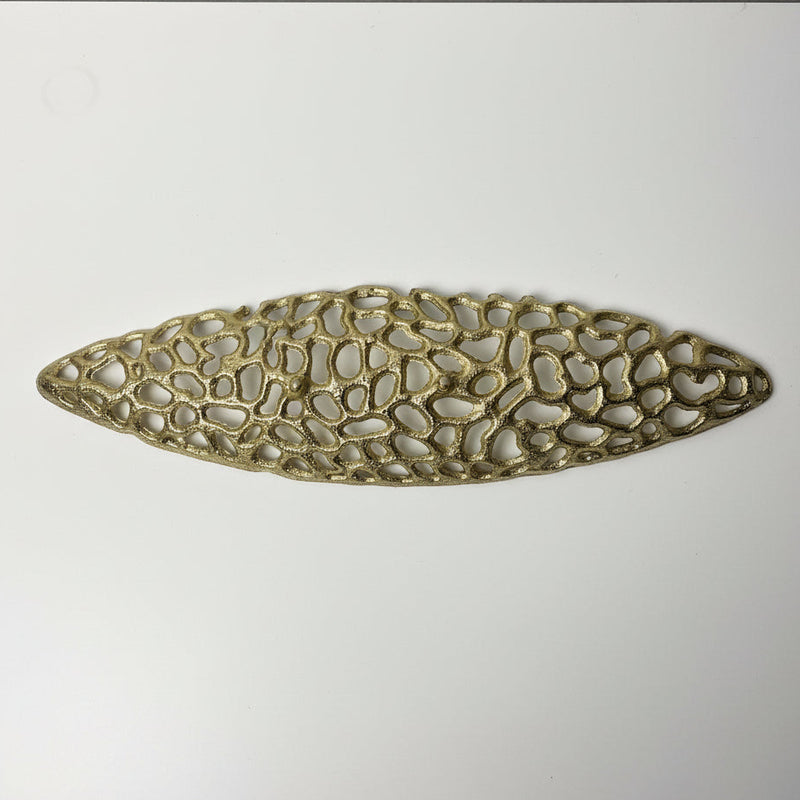 Decorative gold metal tray on a textured white surface showing the bottom view.