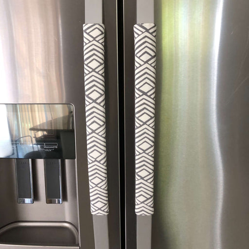 Grey geometric reversible handle covers on a refrigerator, adding style and protection to appliance handles.