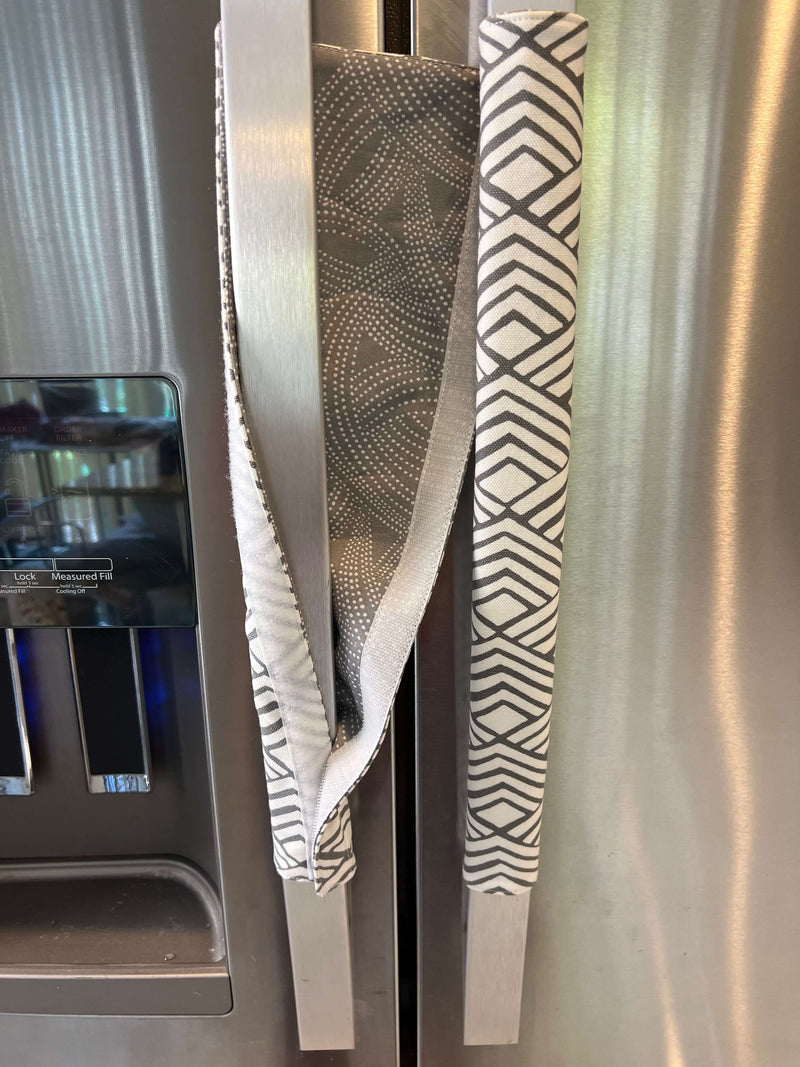Geometric refrigerator handle covers in grey and white, reversible design adding style to kitchen appliances.