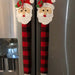 Festive red and black buffalo check appliance handle covers with Santa faces, adding holiday charm to kitchen decor.