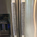 Grey leaf motif appliance handle covers on stainless steel refrigerator handles for added grip and style.