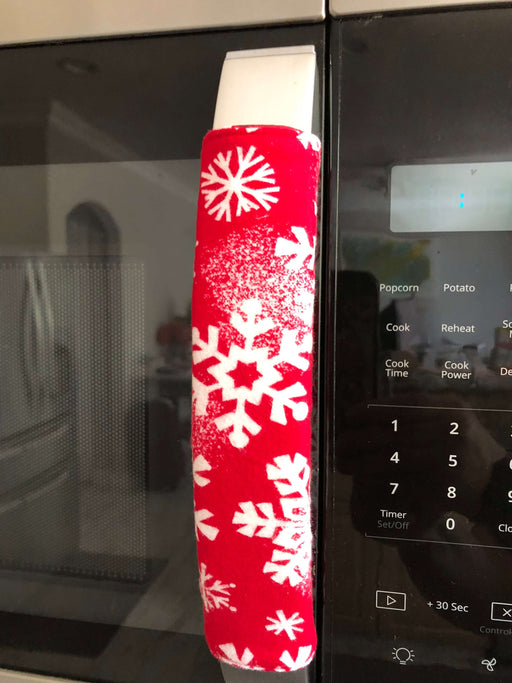 Snowflake design appliance handle cover on a microwave, adding a festive winter touch to the kitchen.