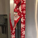 Festive red appliance handle cover with snowflakes and Santa design on a stainless steel fridge.