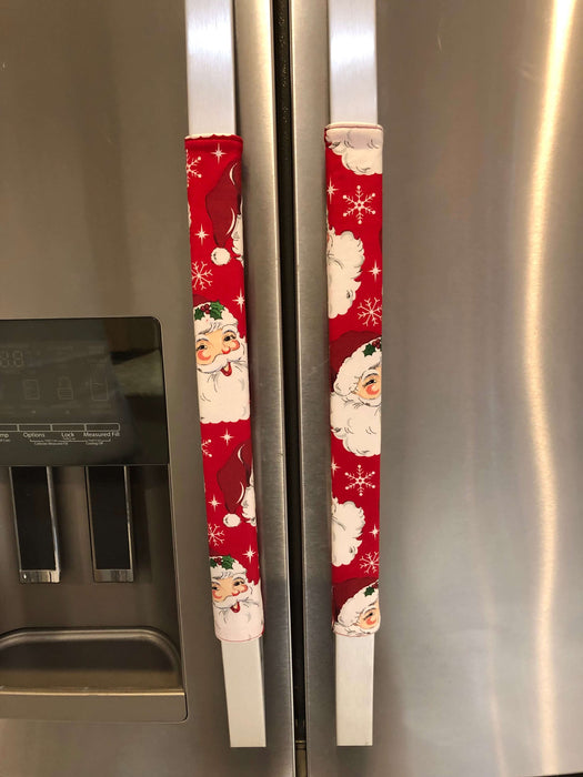 Festive red appliance handle covers with Santa and snowflakes, perfect for holiday kitchen decor.