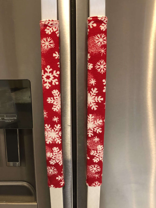 Festive winter snowflakes appliance handle covers on a kitchen refrigerator, adding holiday charm and style.