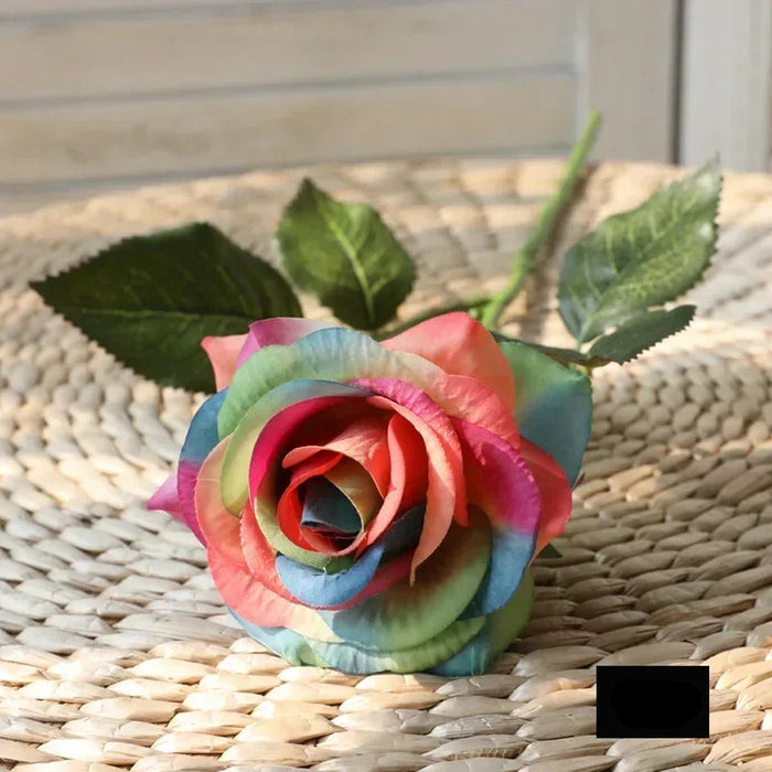 Latex real-touch artificial rose in vibrant rainbow colors on a woven surface, showcasing lifelike beauty and quality.