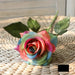 Latex real-touch artificial rose in vibrant rainbow colors on a woven surface, showcasing lifelike beauty and quality.