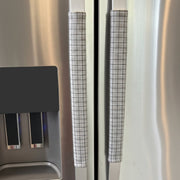 Stainless steel refrigerator with light grey checkered handle covers 