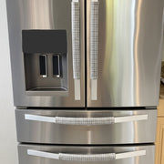 Stainless steel refrigerator with light grey handle covers.