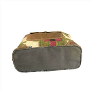 Multi color canvas tote bag with leather pocket, showing the base and durable materials used.