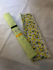 Two mint green Appliance handle covers with ribbon trim, with floral lemon and checkered patterns on a textured surface.