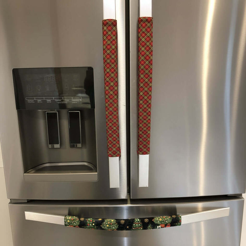Stainless steel refrigerator with decorative handles covers featuring red plaid patterns.