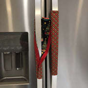 Two Christmas-themed handle covers are attached to a refrigerator.