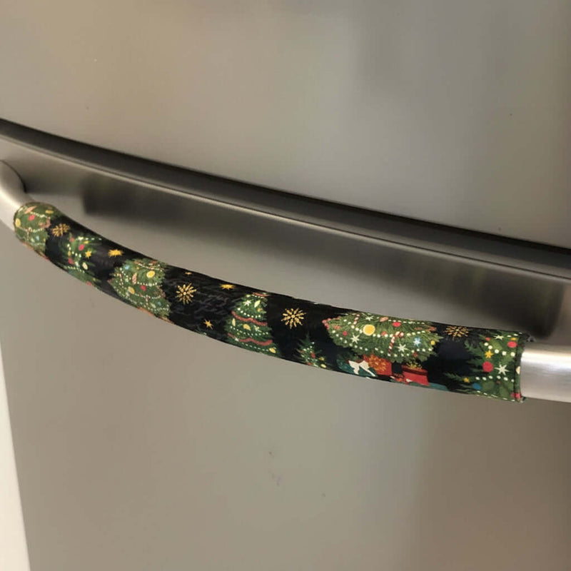 Decorative handle cover with a Christmas tree pattern on a stainless steel fridge.