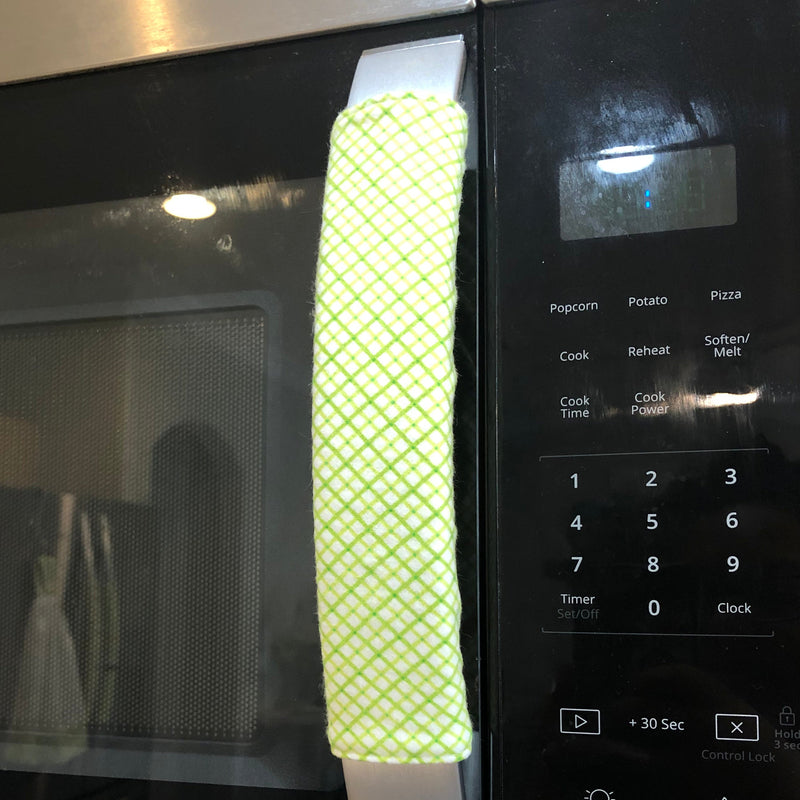 Stainless steel oven with a green diamond-patterned handle cover.