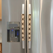 Plaid-patterned handle covers on a refrigerator.