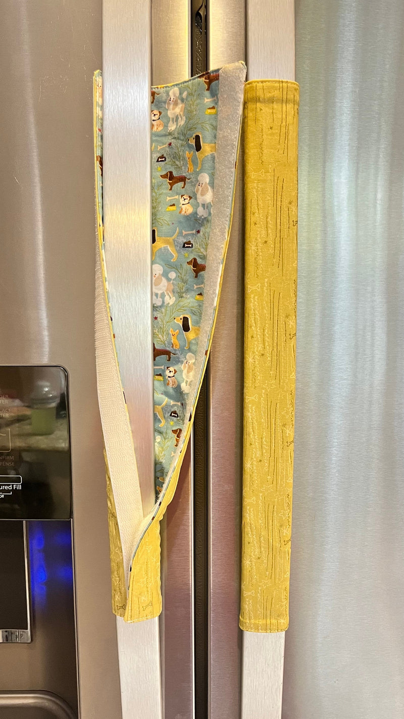 Fridge handles with colorful coverings on a refrigerator.