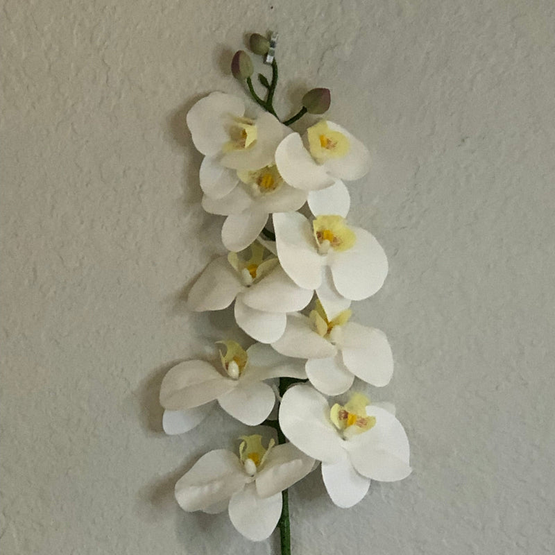 Artificial white orchid flowers on a gray background