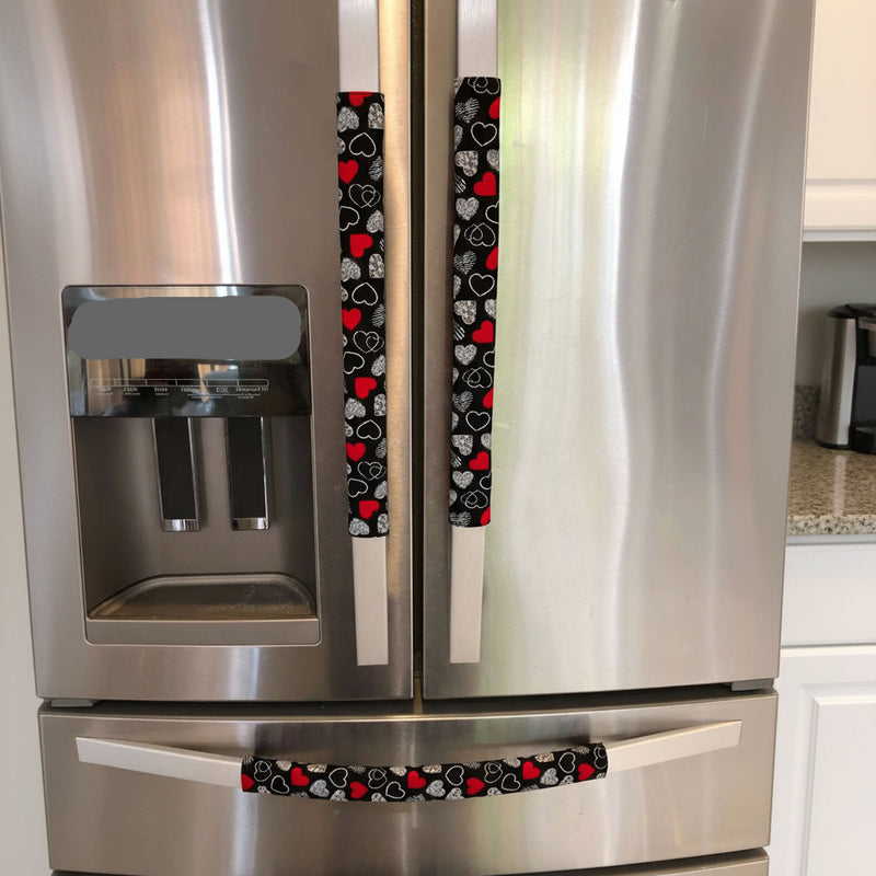 Red and white hearts on black Valentine-themed appliance handle covers.