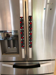 Red and white hearts on black Valentine-themed appliance handle covers on a refrigerator.