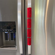 Red flannel handle cover with decorative elements on a fridge.