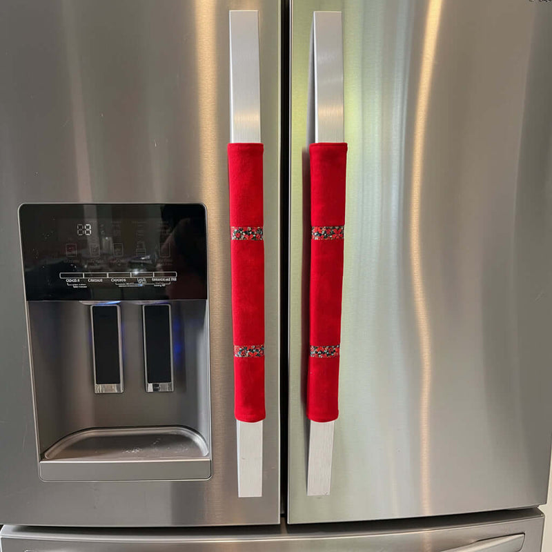 Red cotton flannel handle covers with poinsettia ribbon trim on a stainless steel appliance.