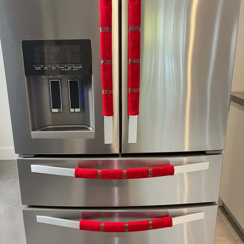 Stainless steel appliance with red handle covers.