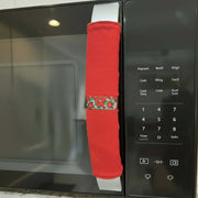 Red microwave handle cover with a pattern on a microwave.