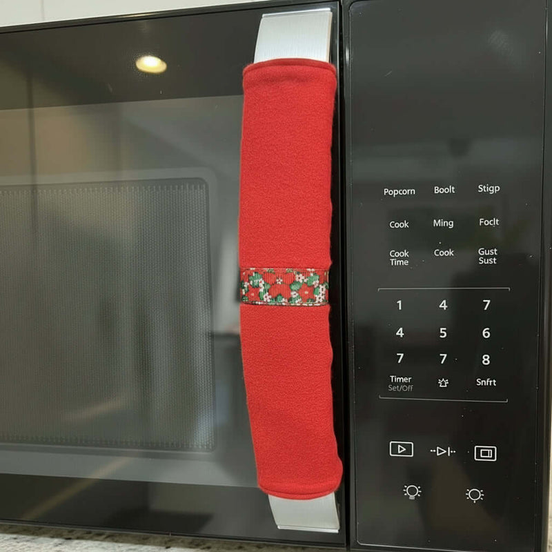 Red microwave handle cover with a pattern on a microwave.