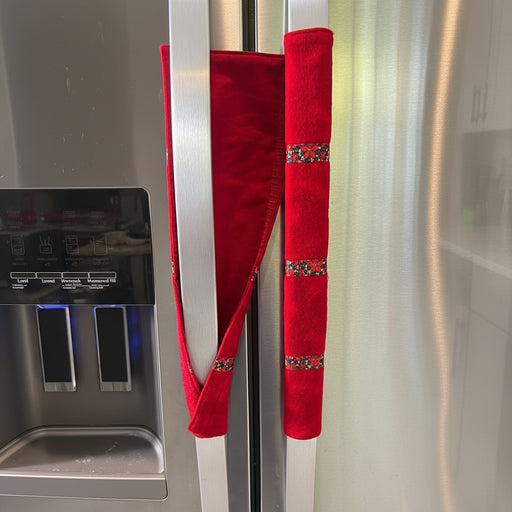 Red handle cover with decorative patterns on a stainless steel fridge.